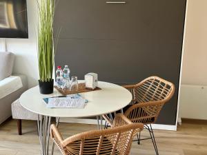uma mesa branca com cadeiras e uma mesa com uma planta em VARENNA GUEST HOUSE 2 em Varenna