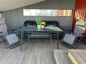 patio ze stołem i krzesłami na tarasie w obiekcie Leirvåg w mieście Bukta