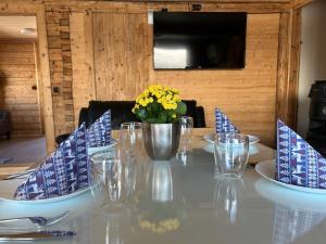 stół z niebiesko-białymi krzesłami i kwiatami w obiekcie Leirvåg w mieście Bukta