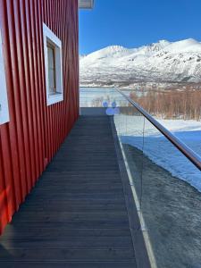 klatka schodowa prowadząca do czerwonego budynku ze śniegiem pokrytymi górami w obiekcie Leirvåg w mieście Bukta