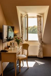 ein Heimbüro mit einem Schreibtisch und einem Fenster in der Unterkunft Café Wildau Hotel & Restaurant am Werbellinsee in Schorfheide