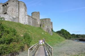 a group of people standing on a bridge in front of a castle at Gorgeous dog friendly cottage in Kidwelly