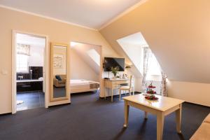 Cette chambre comprend un lit et un bureau avec une table. dans l'établissement Café Wildau Hotel & Restaurant am Werbellinsee, à Schorfheide