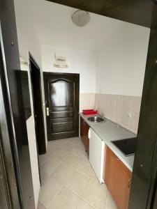 a kitchen with a black door and a sink at Renome in Petrovac na Moru