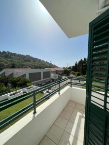 a balcony with a green door and a view at Renome in Petrovac na Moru