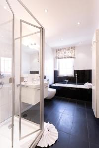 ein Badezimmer mit einer Dusche, einem Waschbecken und einer Badewanne in der Unterkunft Café Wildau Hotel & Restaurant am Werbellinsee in Schorfheide