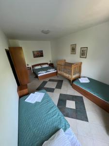 a room with two beds and a checkerboard floor at Renome in Petrovac na Moru