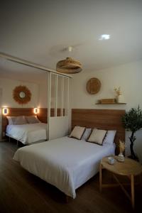 una camera da letto con due letti e un tavolo di La paillotte - Studio terrasse proche tram a Montpellier