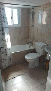 a bathroom with a toilet and a tub and a sink at Peaceful Beach Location in Limassol +19 photos