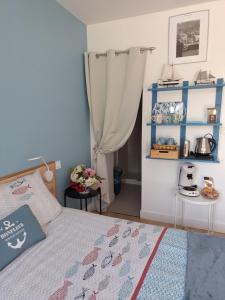 a bedroom with a bed and a blue curtain at La mare aux petits diables in Équemauville