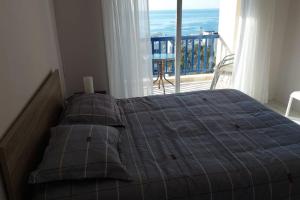 a bed in a bedroom with a view of a balcony at Peaceful Beach Location in Limassol