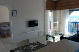a living room with a couch and a tv on a wall at Peaceful Beach Location in Limassol