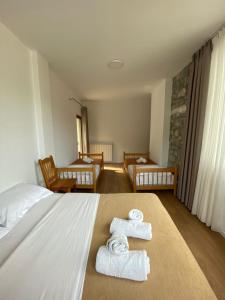 1 dormitorio con 1 cama con toallas en Hotel Vellezrit Guri, en Theth