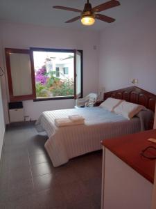 Un dormitorio con dos camas y una ventana. en Apart Los Menhires, en Termas de Río Hondo