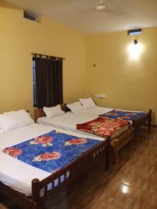two beds sitting in a room with at Mist Valley in Masinagudi
