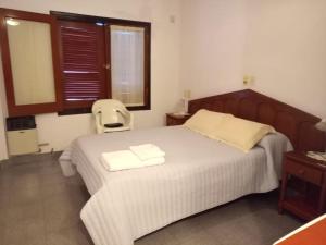 een slaapkamer met een bed met twee handdoeken erop bij Apart Los Menhires in Termas de Río Hondo