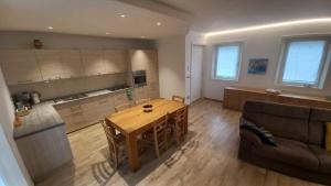 a living room with a wooden table and a couch at Casa di Gaia in Mosnigo