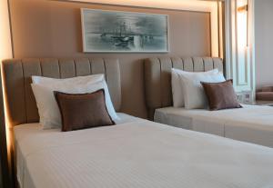 two beds in a hotel room with two pillows at Vira Otel Suites in Sinop