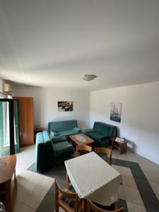a living room with two green couches and a table at Renome in Petrovac na Moru