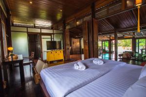 Un pat sau paturi într-o cameră la Baankwaeom Boutique Homestay Amphawa +44 fotografii