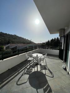 a patio with a table and chairs on a balcony at Renome in Petrovac na Moru