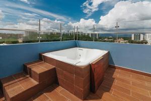 d'une baignoire installée sur le côté d'un balcon. dans l'établissement Modern Luxury Apt w Outdoor Jacuzzi, à Santiago de los Caballeros