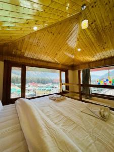 uma cama grande num quarto com janelas em The Exotic Retreat em Manali