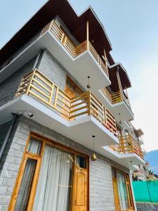 a building with wooden balconies on the side of it at The Exotic Retreat in Manāli