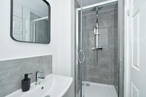 a white bathroom with a sink and a shower at Sapphire Apartments by YourStays - Luxury 2 Bedroom Apartments in Crewe in Crewe