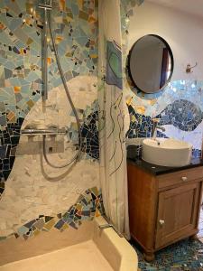 ein Bad mit einer Dusche, einem Waschbecken und einem Spiegel in der Unterkunft Pension Solvang in Rønne