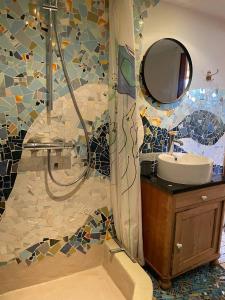 a bathroom with a shower with a sink and a mirror at Homestay in charming house on the countryside in Rønne