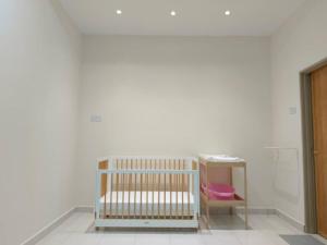 a crib in a room with a white wall at Homestay Sitiawan 53 in Sitiawan