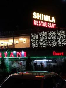 a shilinx restaurant with a neon sign in front of it at Amar Priya guest house in Kolkata