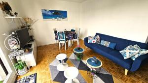 a living room with a blue couch and a table at Appartement avec balcon proche Paris & Disneyland in Champigny-sur-Marne