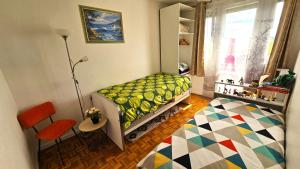 - une chambre avec un lit, une table et une fenêtre dans l'établissement Appartement avec balcon proche Paris & Disneyland, à Champigny-sur-Marne