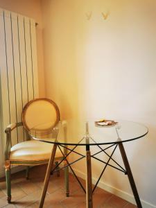 un tavolo in vetro con una sedia, un tavolo in vetro e un tavolo di Dolce Farnetta en-Suite Spa & Yoga a Montecastrilli