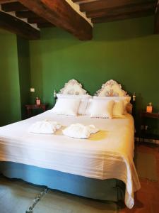 1 dormitorio con 1 cama grande con sábanas y almohadas blancas en Dolce Farnetta en-Suite Spa & Yoga en Montecastrilli