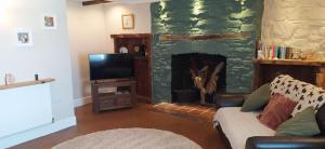 a living room with a fireplace and a couch at Gorgeous dog friendly cottage in Kidwelly