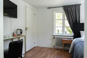 a bedroom with a bed and a desk and a window at långstorp in Långstorp