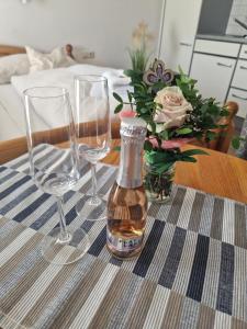 a table with two wine glasses and a vase with flowers at Appartement Haus Sonnenheim in Zell am See
