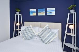 a bedroom with blue walls and a bed with pillows at Sapphire Apartments by YourStays - Luxury 2 Bedroom Apartments in Crewe in Crewe