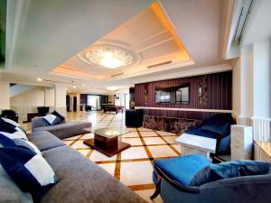 una gran sala de estar con sofás y chimenea. en ELAN RIMAL SADAF Suites en Dubái
