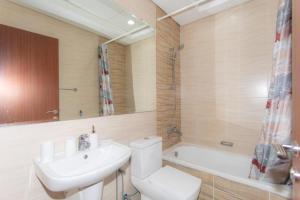 a bathroom with a toilet and a sink and a tub at Fully Furnished Studio In JVC RL in Dubai
