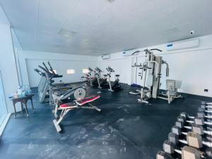 a gym with several tread machines in a room at Fully Furnished Studio In JVC RL in Dubai