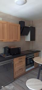La cuisine est équipée de placards en bois et d'un four avec plaques de cuisson. dans l'établissement Appartement de standing : 2 chambres, à Raismes