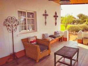 a living room with wicker chairs and a window at Romantic Vintage Cottage, Views across vineyards. in Currieʼs Camp