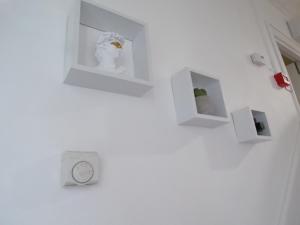 a white wall with shelves and a clock on it at Top Chiswick Apartments, London Center Area in London