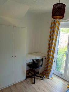 uma secretária e uma cadeira num quarto com uma janela em Cozy stay em Southampton
