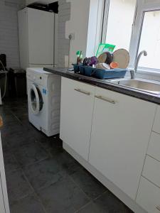 uma cozinha com um lavatório e uma máquina de lavar roupa em Cozy stay em Southampton