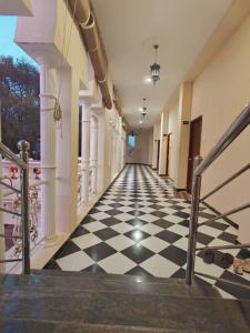 an empty hallway with a black and white checkered floor at Chola Heritage Resort in Kāraikkudi